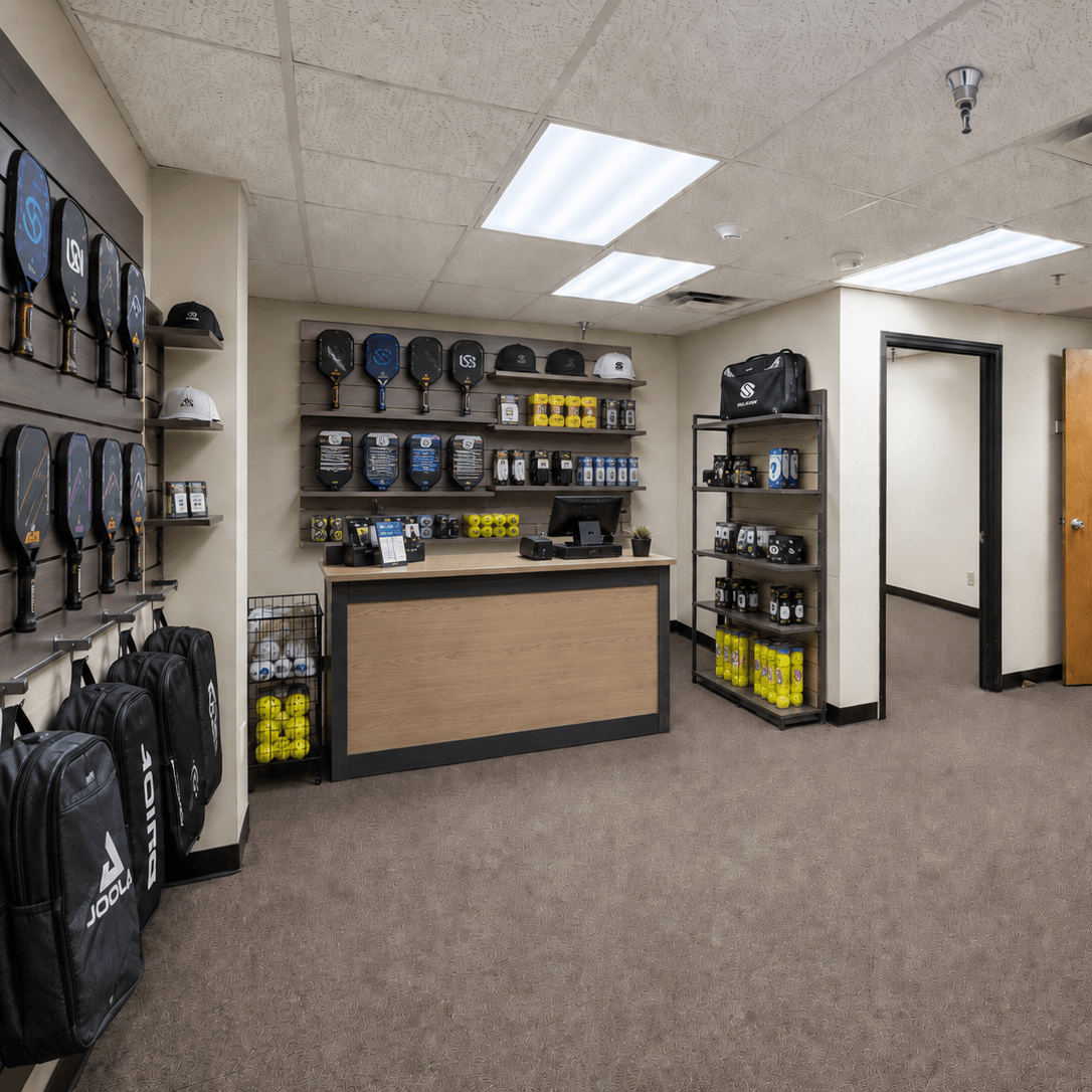 Store interior with sports equipment and clothing on shelves and racks.