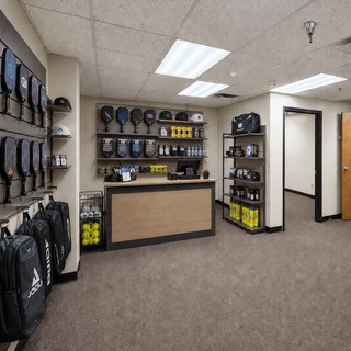 Store interior with sports equipment and clothing on shelves and racks.